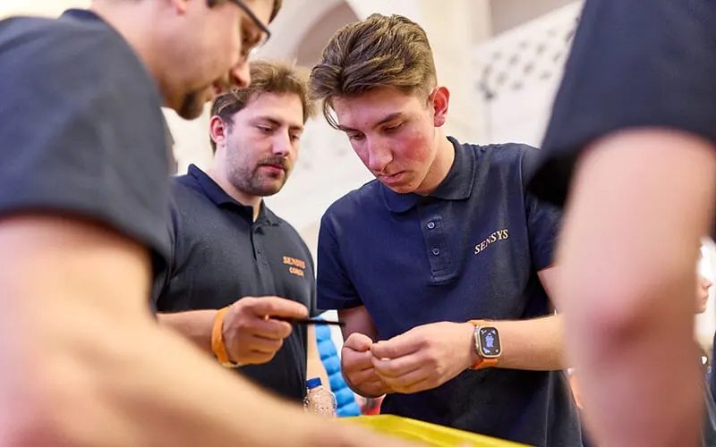Team members preparing the robot together for the competition