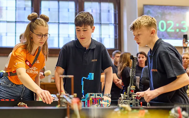 Team members speaking with a coach at the competition table